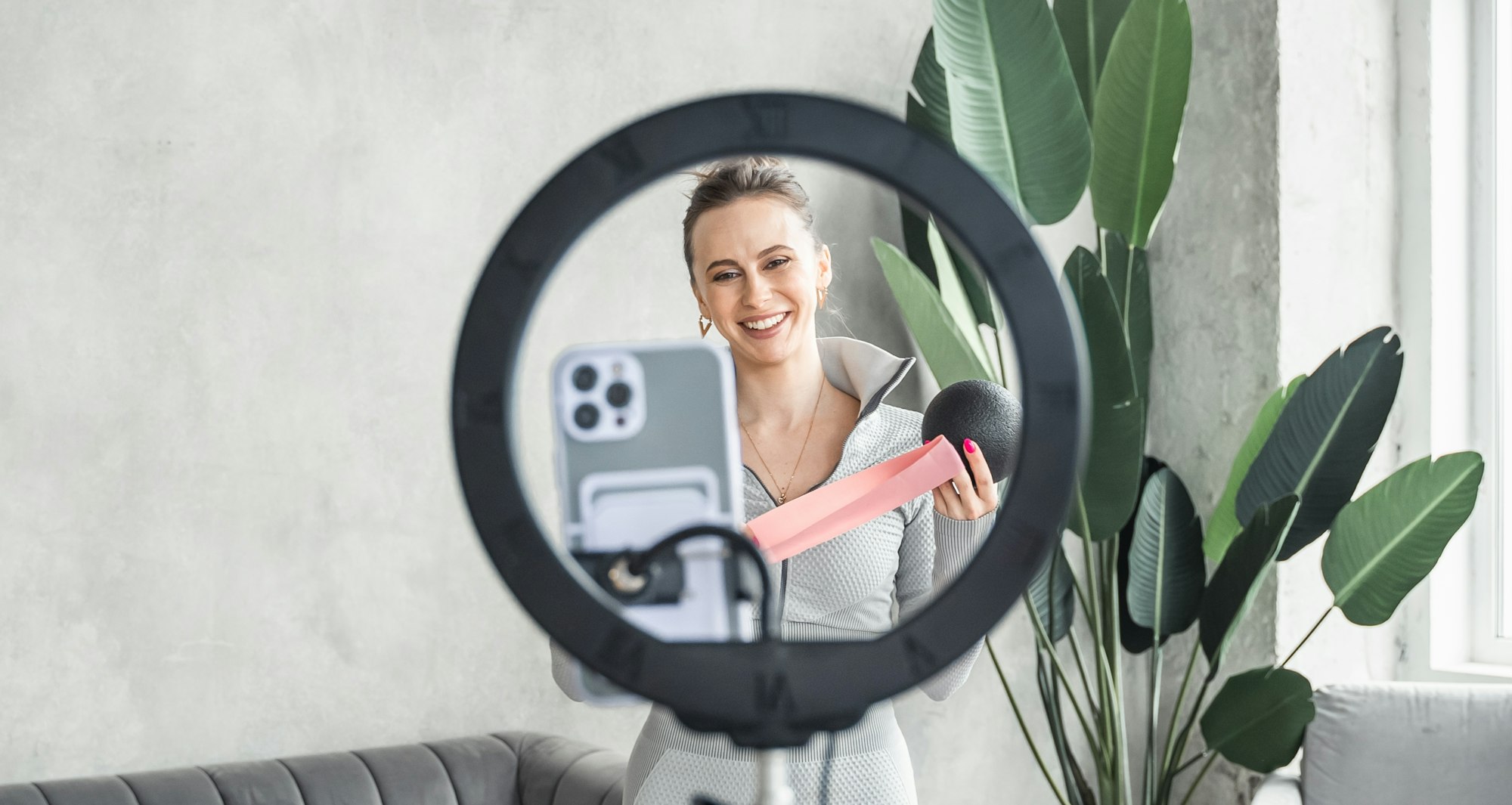 Young sporty slim woman yoga coach, female fitness instructor records video of online yoga training.